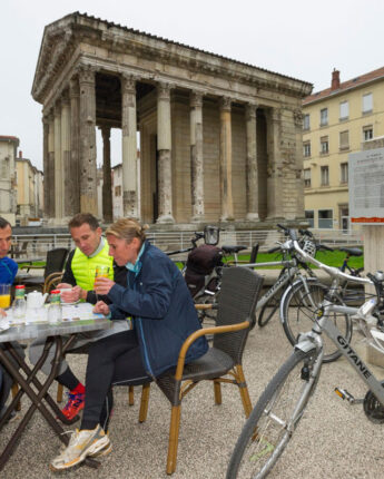 Personnes buvant un café avec leur vélo devant le Temple d'Auguste et de Livie